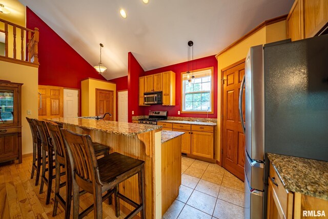 4627 S Queen Aleta Ct, Mapleton, IL 61547 - kitchen with appliances with stainless steel finishes, stone counters, a breakfast bar, a kitchen island with sink, and pendant lighting