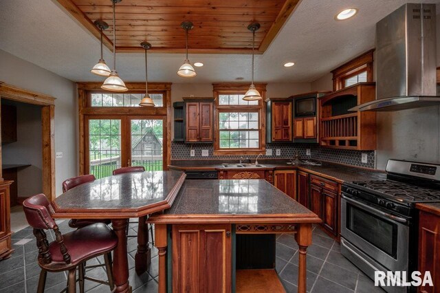 307 N Logan St, Deer Creek, IL 61733 - kitchen with gas stove, open shelves, dark countertops, wall chimney exhaust hood, and decorative backsplash