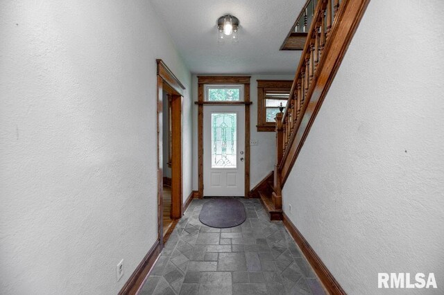 307 N Logan St, Deer Creek, IL 61733 - doorway featuring baseboards, stairs, dark stone finish floors, and a textured wall