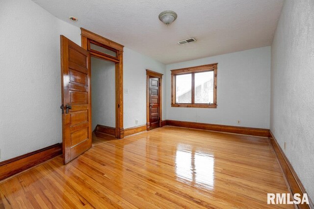 307 N Logan St, Deer Creek, IL 61733 - spare room featuring light wood-style flooring, baseboards, and a textured wall