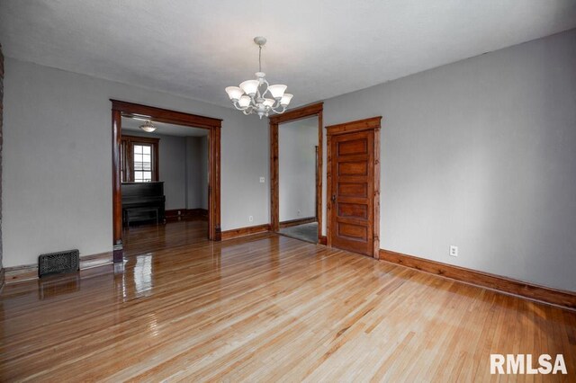 307 N Logan St, Deer Creek, IL 61733 - spare room featuring a chandelier, baseboards, and light wood-style floors