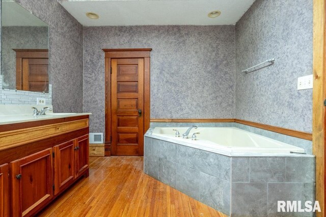 307 N Logan St, Deer Creek, IL 61733 - full bath with wood finished floors, vanity, and a bath