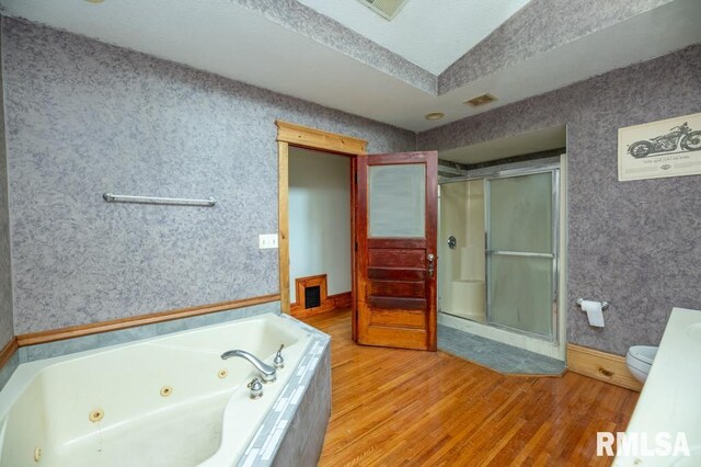307 N Logan St, Deer Creek, IL 61733 - full bathroom featuring wood finished floors, a stall shower, a jetted tub, and toilet
