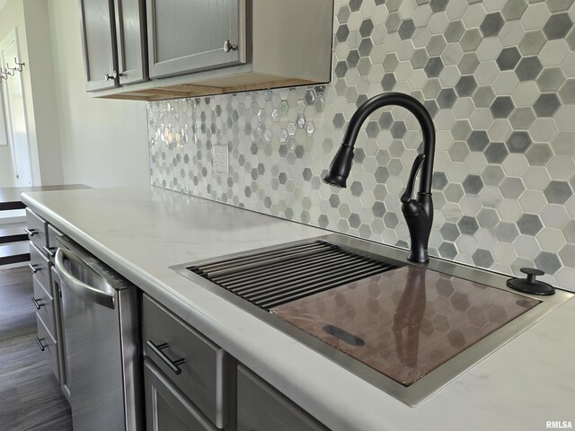 433 N Prairie Ave, Macomb, IL 61455 - kitchen view of backsplash, stainless steel dishwasher, light countertops, and wood finished floors