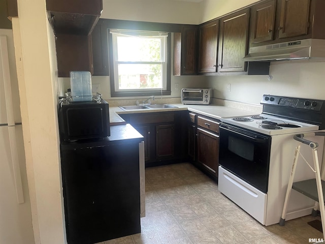 427 W Orchard St, Macomb, IL 61455 - kitchen featuring electric range oven, under cabinet range hood, dark brown cabinetry, and light countertops