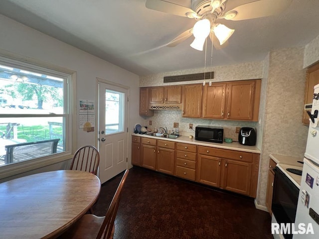 510 W Kelly St, Macomb, IL 61455 - kitchen with black microwave, electric range, light countertops, a ceiling fan, and brown cabinetry
