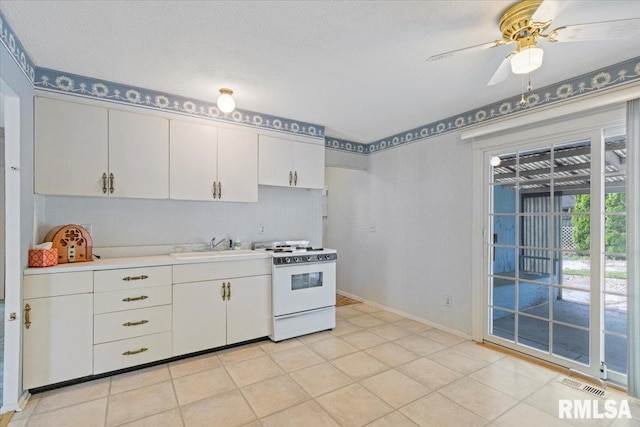 1810 Windsor St, Pekin, IL 61554 - kitchen with white range with gas stovetop, light countertops, white cabinetry, a ceiling fan, and light tile patterned flooring
