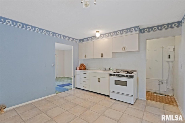 1810 Windsor St, Pekin, IL 61554 - kitchen with white gas stove, white cabinets, decorative backsplash, light countertops, and light tile patterned floors