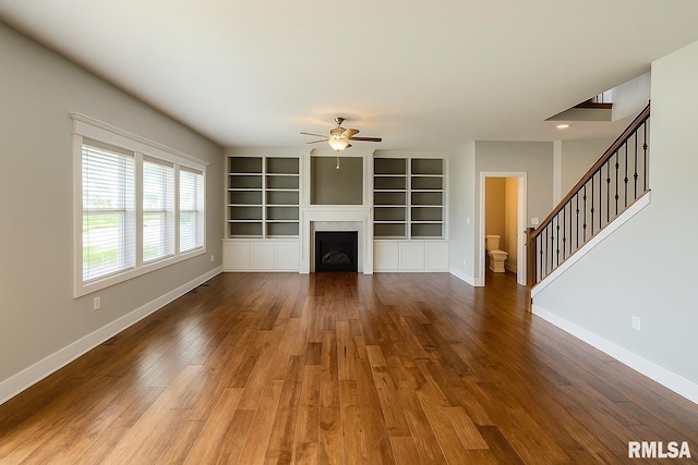 308 Pocono Ave, Morton, IL 61550 - unfurnished living room featuring ceiling fan, wood finished floors, a fireplace, stairway, and built in shelves