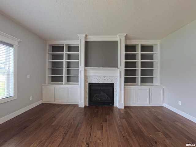 308 Pocono Ave, Morton, IL 61550 - unfurnished living room featuring built in shelves, a premium fireplace, wood finished floors, and a textured ceiling