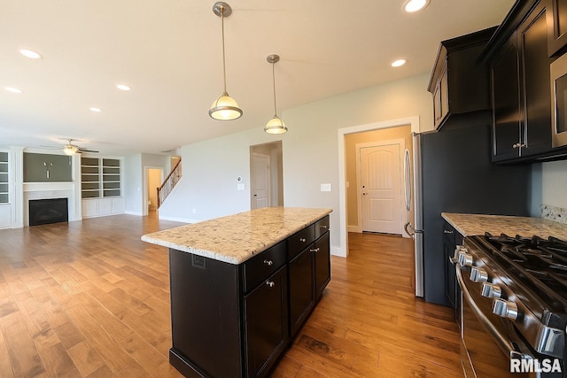 308 Pocono Ave, Morton, IL 61550 - kitchen featuring ceiling fan, a kitchen island, gas range, light wood-type flooring, and pendant lighting