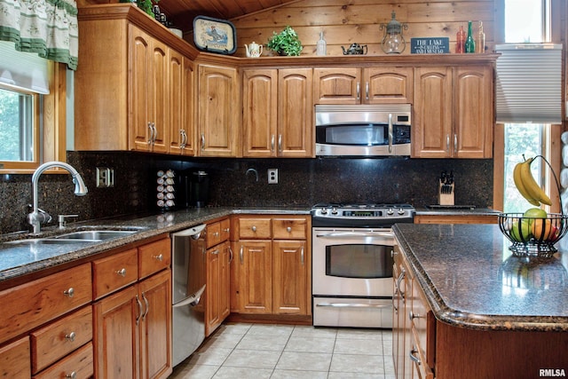 7019 Oak Run Dr, Dahinda, IL 61428 - kitchen with appliances with stainless steel finishes, light tile patterned floors, brown cabinetry, lofted ceiling, and dark stone countertops