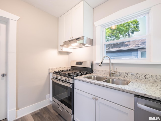 600 E Virginia Ave, Peoria, IL 61603 - kitchen with stainless steel appliances, under cabinet range hood, dark wood finished floors, white cabinetry, and light stone countertops