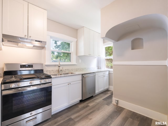 600 E Virginia Ave, Peoria, IL 61603 - kitchen featuring under cabinet range hood, appliances with stainless steel finishes, dark wood-type flooring, white cabinets, and plenty of natural light