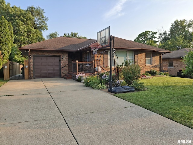 2604 W Kansas St, Peoria, IL 61604 - view of front of house with an attached garage, brick siding, concrete driveway, a front yard, and a gate
