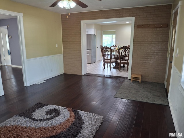 2604 W Kansas St, Peoria, IL 61604 - dining area featuring a ceiling fan, wainscoting, dark wood-style floors, and brick wall