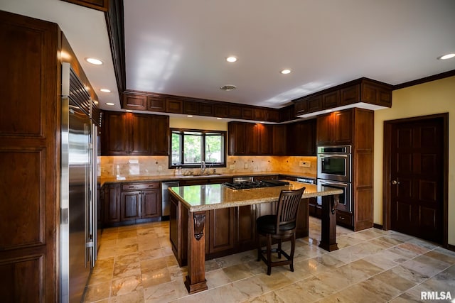 241 Birch Pl, Kewanee, IL 61443 - kitchen with appliances with stainless steel finishes, backsplash, a kitchen island, a breakfast bar area, and light stone finish flooring