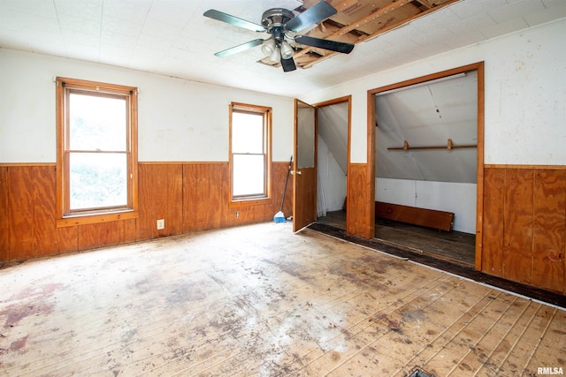 7113 S Depot St, Bartonville, IL 61607 - spare room featuring wainscoting, wooden walls, a ceiling fan, and wood-type flooring