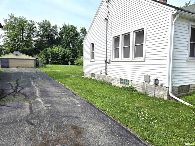 904 E Elm St, Canton, IL 61520 - view of home's exterior featuring a yard, a detached garage, a chimney, and an outdoor structure