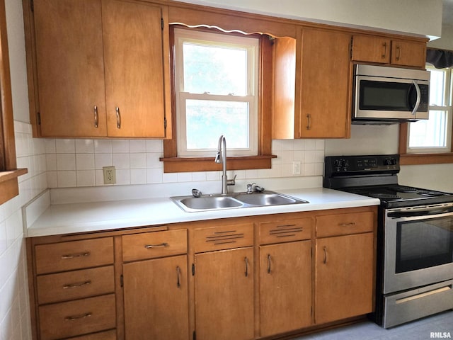 904 E Elm St, Canton, IL 61520 - kitchen with appliances with stainless steel finishes, light countertops, plenty of natural light, and decorative backsplash