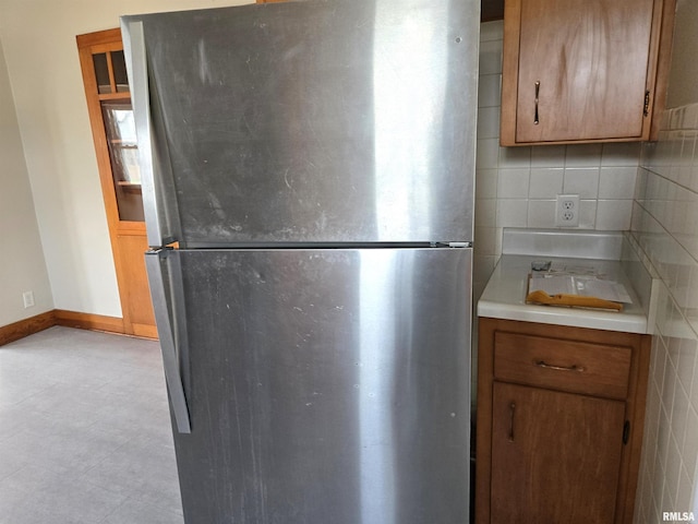 904 E Elm St, Canton, IL 61520 - kitchen with freestanding refrigerator, light countertops, and brown cabinetry