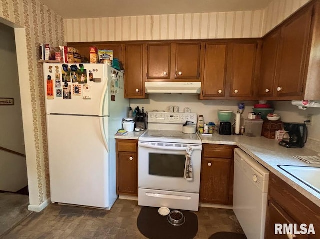 218 W Kurlene Dr, Macomb, IL 61455 - kitchen with white appliances, under cabinet range hood, wallpapered walls, light countertops, and brown cabinetry
