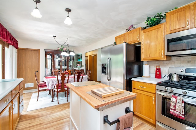100 Oakridge Ct, Dahinda, IL 61428 - kitchen featuring stainless steel appliances, butcher block countertops, light wood finished floors, and decorative backsplash