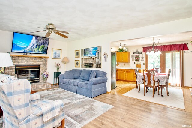 100 Oakridge Ct, Dahinda, IL 61428 - living area with a fireplace, a ceiling fan, and light wood finished floors