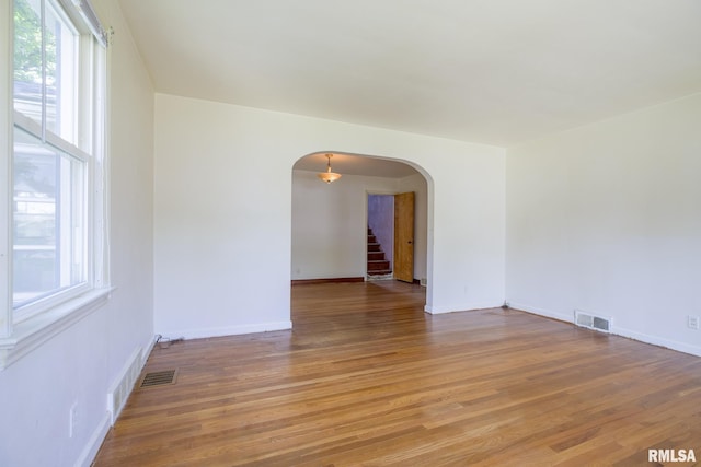 1030 E Euclid Ave, Peoria Heights, IL 61616 - empty room featuring arched walkways, light wood-type flooring, and stairway