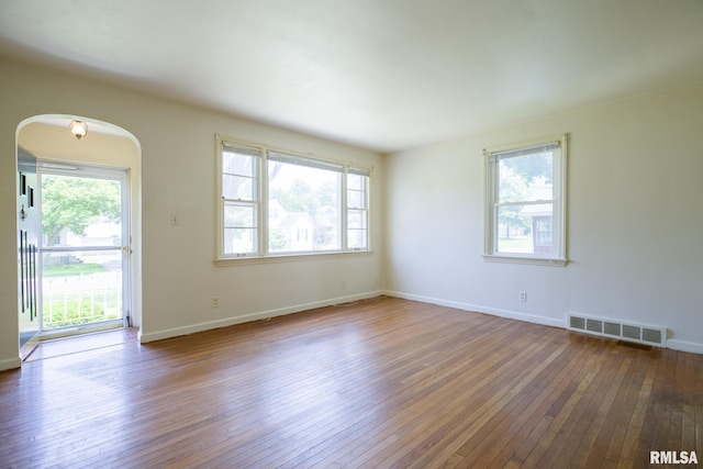 1030 E Euclid Ave, Peoria Heights, IL 61616 - unfurnished room featuring plenty of natural light, arched walkways, and wood-type flooring