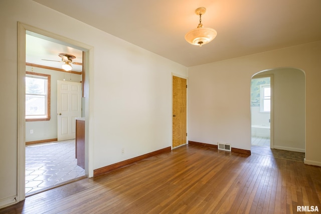 1030 E Euclid Ave, Peoria Heights, IL 61616 - unfurnished room featuring arched walkways, hardwood / wood-style floors, and a ceiling fan
