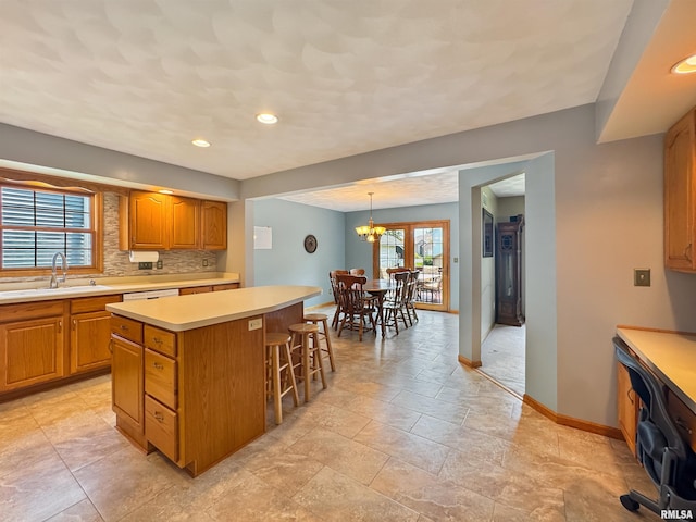 125 Prairieview Dr, East Peoria, IL 61611 - kitchen with light countertops, a kitchen island, a kitchen breakfast bar, tasteful backsplash, and recessed lighting