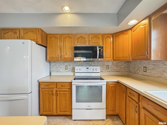 125 Prairieview Dr, East Peoria, IL 61611 - kitchen with white appliances, light countertops, decorative backsplash, brown cabinetry, and recessed lighting