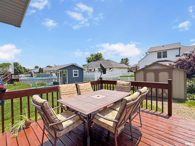 125 Prairieview Dr, East Peoria, IL 61611 - wooden terrace with a storage unit, outdoor dining space, a residential view, a fenced backyard, and an outdoor pool