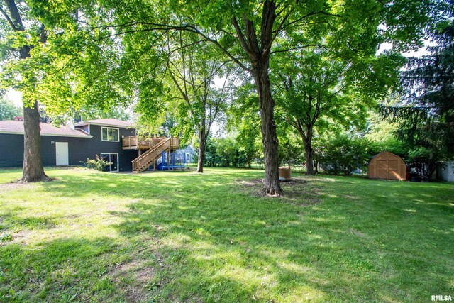 324 Pinecrest Dr, Germantown Hills, IL 61548 - view of green lawn with stairway, a storage unit, and a wooden deck