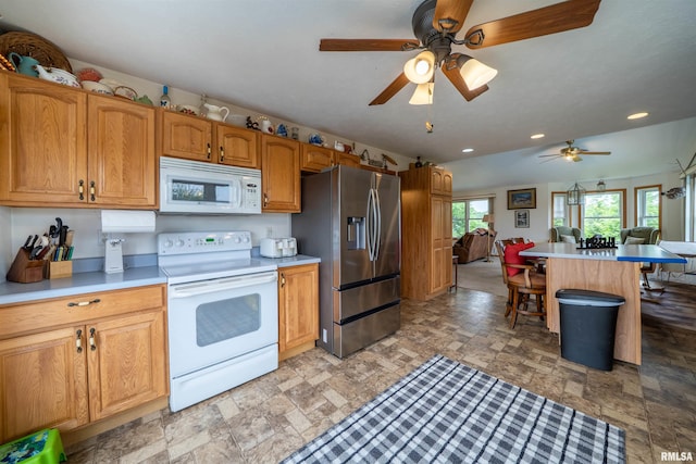 21501 N Berchtold Rd, Chillicothe, IL 61523 - kitchen with white appliances, stone finish floors, ceiling fan, a kitchen breakfast bar, and open floor plan
