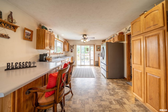 21501 N Berchtold Rd, Chillicothe, IL 61523 - kitchen featuring stainless steel refrigerator with ice dispenser, light stone finish flooring, light countertops, a ceiling fan, and a textured ceiling