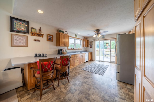 21501 N Berchtold Rd, Chillicothe, IL 61523 - kitchen featuring freestanding refrigerator, white dishwasher, light countertops, a ceiling fan, and stone finish floors
