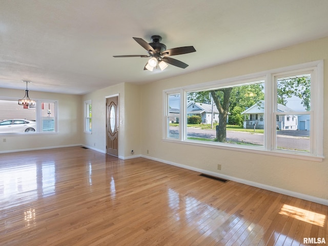 621 E Sciota Ave, Peoria Heights, IL 61616 - unfurnished living room featuring light wood finished floors, a ceiling fan, and a chandelier