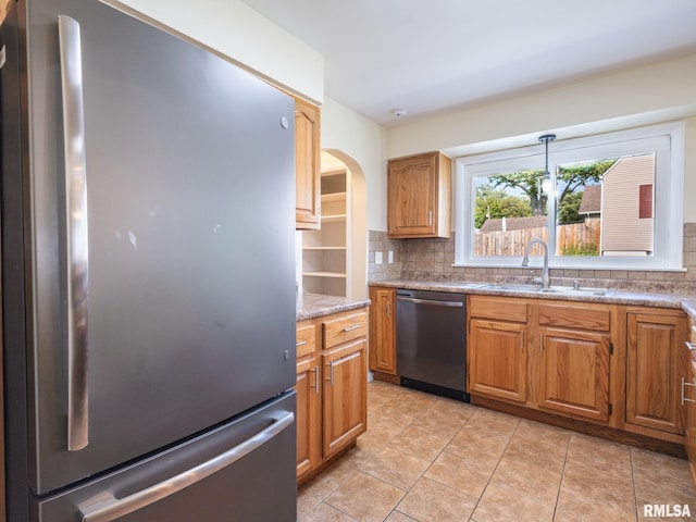 621 E Sciota Ave, Peoria Heights, IL 61616 - kitchen with appliances with stainless steel finishes, decorative backsplash, arched walkways, and light tile patterned floors