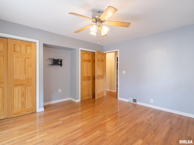 621 E Sciota Ave, Peoria Heights, IL 61616 - unfurnished bedroom with multiple closets, light wood-style flooring, and a ceiling fan