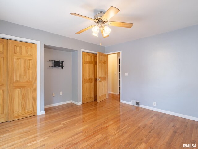 621 E Sciota Ave, Peoria Heights, IL 61616 - unfurnished bedroom featuring multiple closets, light wood-type flooring, and ceiling fan