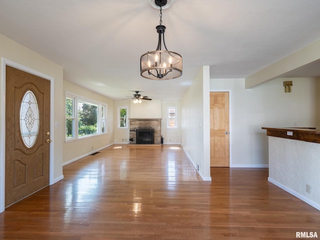 621 E Sciota Ave, Peoria Heights, IL 61616 - entrance foyer featuring a chandelier, ceiling fan, wood finished floors, and a fireplace with raised hearth