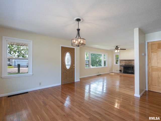 621 E Sciota Ave, Peoria Heights, IL 61616 - foyer entrance with a fireplace, light wood-style flooring, a chandelier, and a ceiling fan