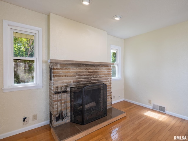 621 E Sciota Ave, Peoria Heights, IL 61616 - unfurnished living room featuring a fireplace, hardwood / wood-style flooring, and healthy amount of natural light