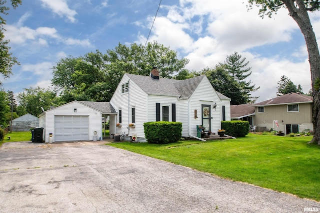 202 Esser St, Washington, IL 61571 - view of front of home with an outdoor structure, roof with shingles, a chimney, a front yard, and driveway