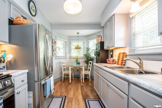 202 Esser St, Washington, IL 61571 - kitchen featuring stainless steel appliances, light countertops, light wood-type flooring, and pendant lighting