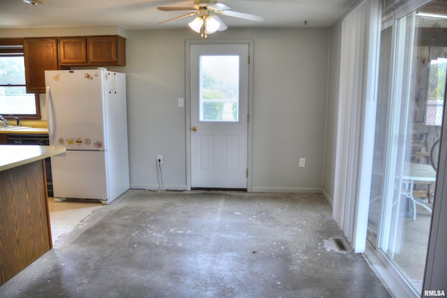 70 Constitution Rd, Colchester, IL 62326 - kitchen featuring freestanding refrigerator, brown cabinets, ceiling fan, and unfinished concrete flooring