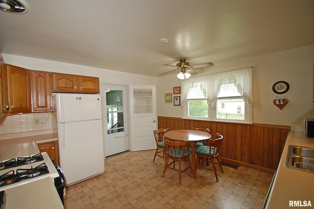 4 Alexander Ln, Bartonville, IL 61607 - kitchen with freestanding refrigerator, wainscoting, ceiling fan, wood walls, and range with gas cooktop