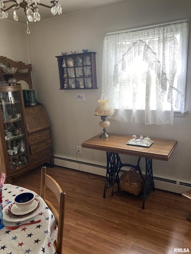 301 N Louise St, La Harpe, IL 61450 - dining area featuring wood finished floors and a baseboard heating unit